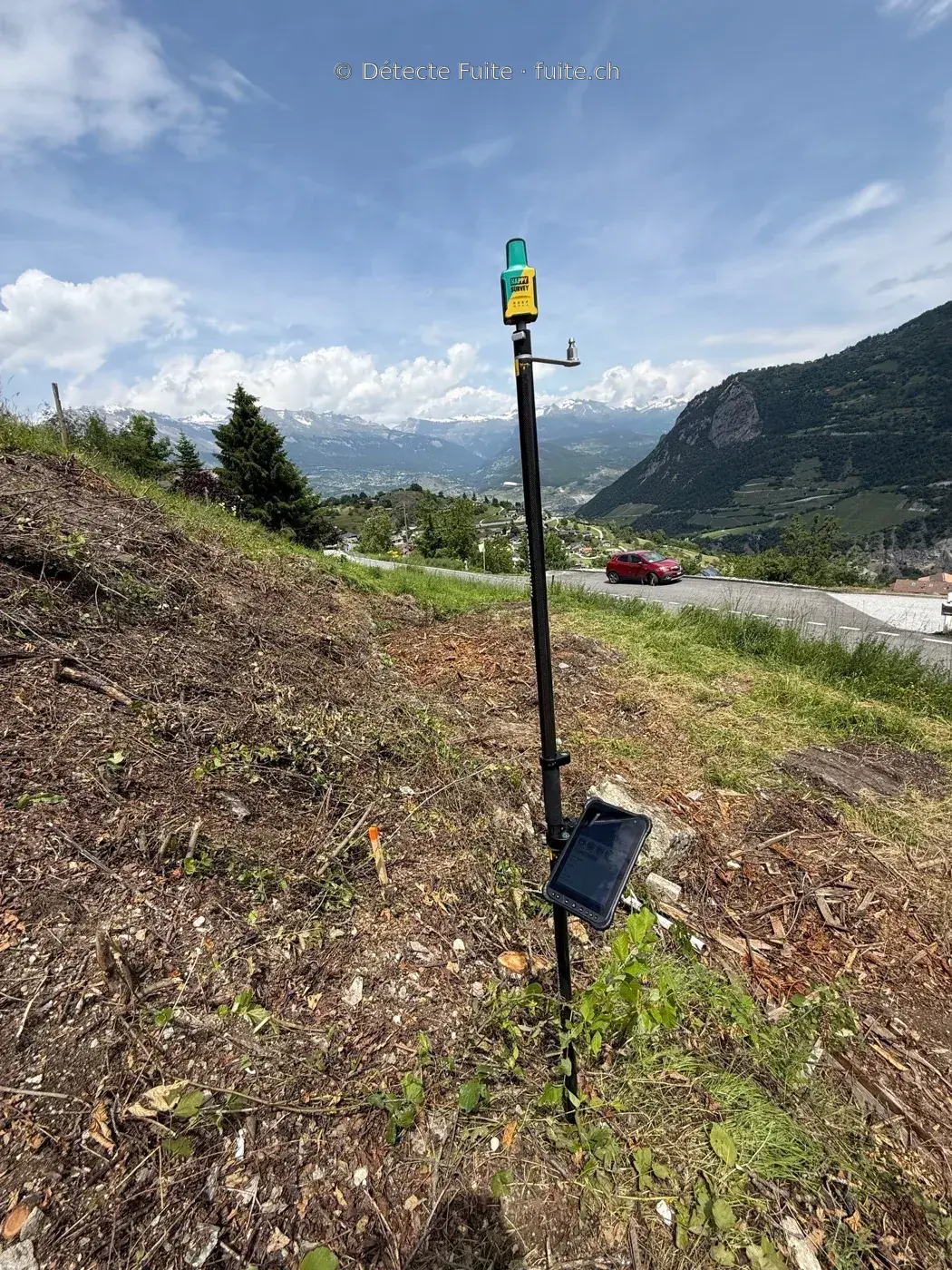 Récepteur GNSS sur une canne de mesure en terrain montagneux